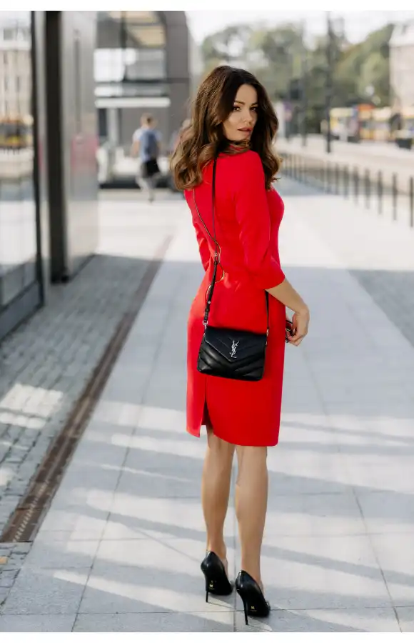 Elegancka, czerwona sukienka przed kolano z widocznym, ozdobnym zamkiem.