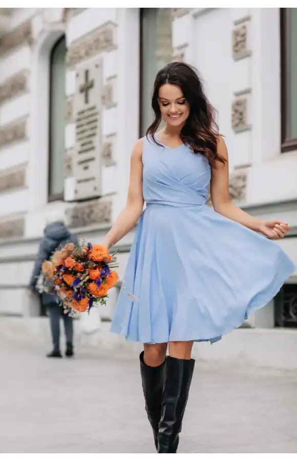 Błękitna sukienka o lekkim kroju z dopasowaną górą i odciętą w talii, rozkloszowaną spódnicą.